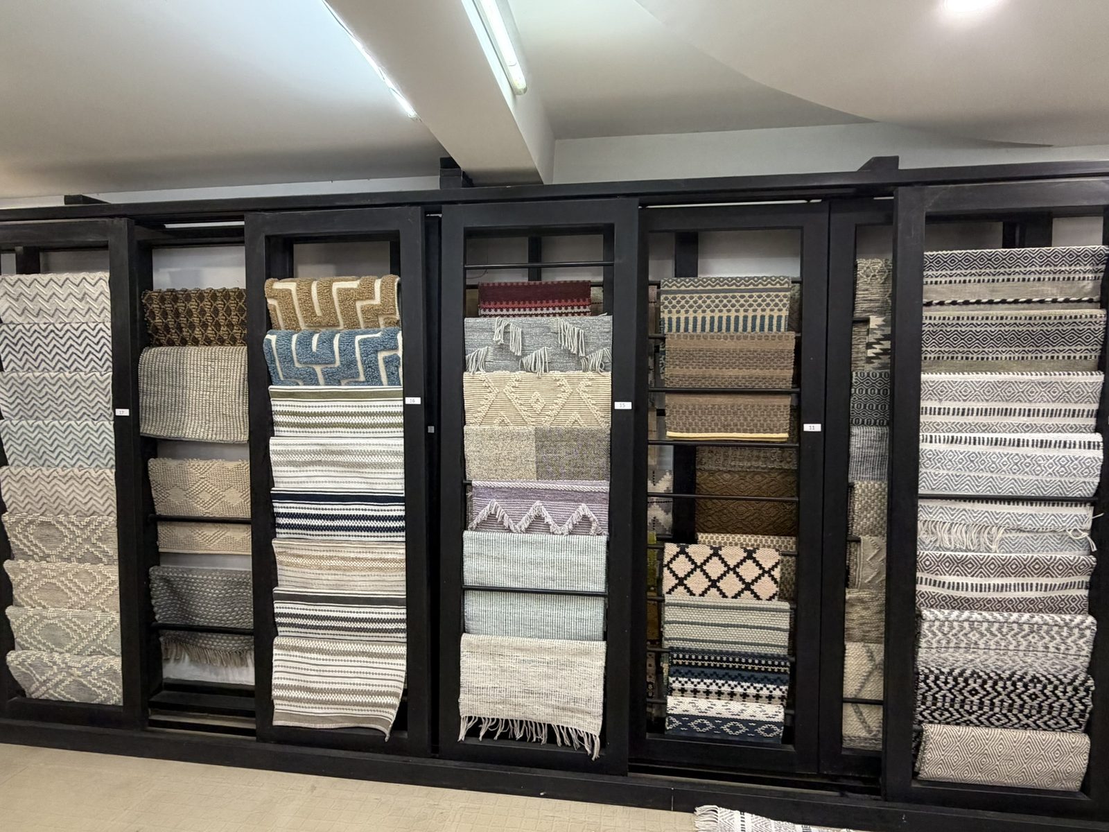 Warp Street showroom with racks of woven rugs and carpets